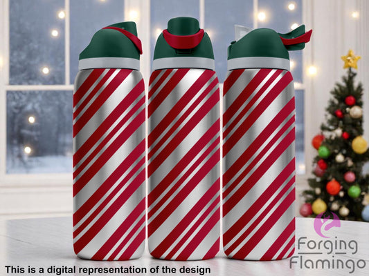 Three stainless steel Owala tumblers with red diagonal candy cane stripe engraving, creating a festive holiday look. Displayed in front of a frosted window with warm lights and a decorated Christmas tree in the background. Forging Flamingo logo appears in the bottom right corner.