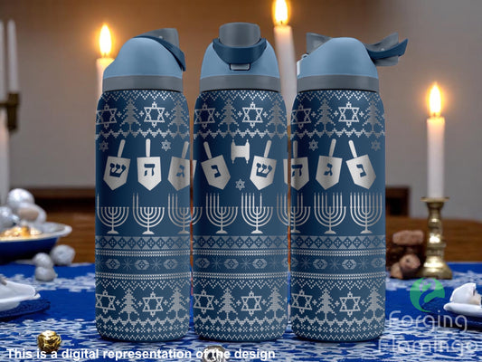 Three blue tumblers with flip-top lids, engraved with Hanukkah-themed designs including dreidels with Hebrew letters, menorahs, Stars of David, and sweater-style patterns, displayed on a festive table with lit candles, gelt, and holiday treats. Text below reads “This is a digital represe