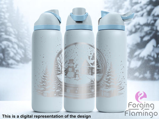 Three light blue tumblers with flip-top lids, engraved with a snow globe scene featuring a snowman, a child snowman, snowy pine trees, a cabin, and falling snow, displayed against a frosty winter background with snow-covered trees. Text below reads “This is a digital representation of the design.”