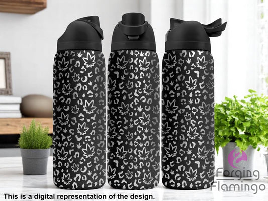 Three black tumblers with flip-top lids, engraved with a pattern of cannabis leaves and leopard print spots, displayed on a modern kitchen counter with small potted plants and books in the background. Text below reads “This is a digital representation of the design.”