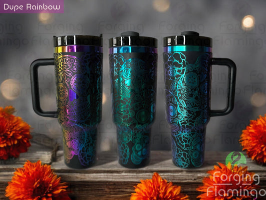 Composite image of a black tumbler with a rainbow base engraved with Forging Flamingo's Dia De Los Muertos design, shown from multiple angles to showcase detailed sugar skulls, marigolds, and celebration motifs in a seamless wrap.