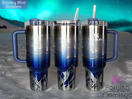 Composite image of a single Non-Branded blue gradient tumbler engraved with Forging Flamingo's Northern Lights with Mountains design, shown from multiple angles to showcase radiant aurora bands above detailed tree lines and mountain peaks in a seamless wrap.