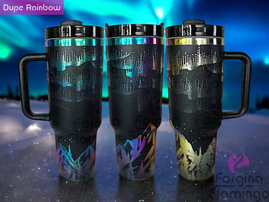 Composite image of a single Non-Branded black tumbler with a rainbow base, engraved with Forging Flamingo's Northern Lights with Mountains design, shown from multiple angles to highlight glowing aurora patterns above silhouetted mountain peaks in a seamless wrap.