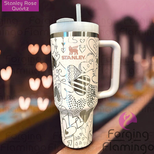 Composite image of a rose quartz Stanley tumbler engraved with Forging Flamingo's Heart Doodles design showcasing a playful assortment of engraved heart illustrations in a continuous wrap.