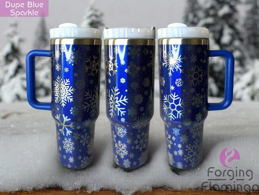 Composite image of a blue sparkle Stanley tumbler engraved with Forging Flamingo's Snowflakes design, displayed from several angles to show shimmering snowflake patterns wrapping fully around the cup.