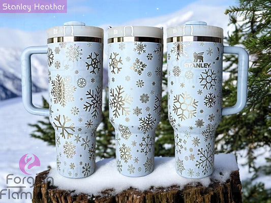 Composite image of a heather Stanley tumbler engraved with Forging Flamingo's Snowflakes design, shown from multiple angles to highlight a variety of snowflake patterns in a seamless, wintry wrap.