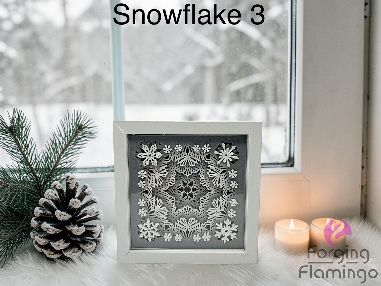 Decorative snowflake art in a frame with winter elements like pine cones and candles.