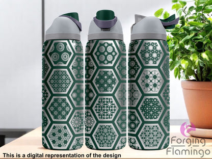 Three Owala tumblers with laser-engraved geometric Arabesque tile patterns inside hexagons, featuring a green and silver color scheme. Displayed indoors on a wooden surface with soft natural light and a potted plant in the background. Forging Flamingo logo appears in the bottom right corner.
