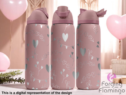 Three mauve pink tumblers with flip-top lids, engraved with a delicate pattern of hearts, bows, and leafy garlands, displayed against a soft romantic background with pink balloons, curtains, and light wood accents. Text below reads “This is a digital representation of the design.”
