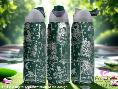 Three dark green Owala tumblers with laser-engraved tarot card designs featuring whimsical frogs representing cards like The Magician, The Lovers, Death, and The Moon. Displayed outdoors in a sunlit, forested setting beside a gently flowing stream. Forging Flamingo logo appears in the bottom right corner.
