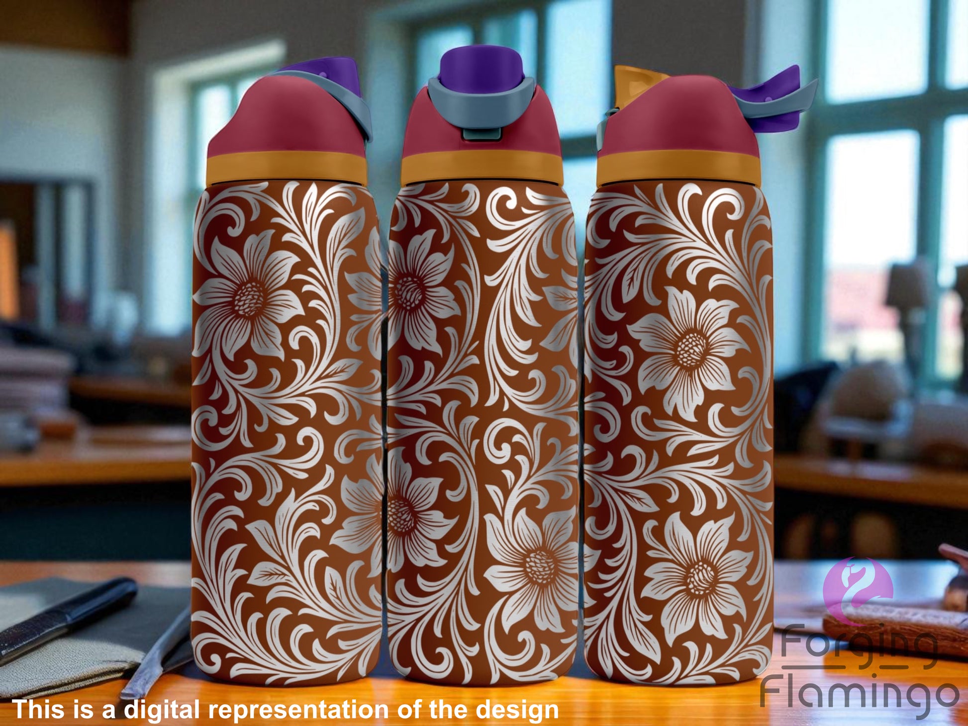 Three brown Owala tumblers featuring a laser-engraved leather tooling in a western floral design with large flowers and swirling paisley-style scrollwork. The wraparound pattern is engraved in white and highly detailed. Each tumbler has a rose-colored lid with a gold accent band and differently colored spouts. The background shows a softly lit indoor setting with desks and windows. Forging Flamingo logo in the bottom right.
