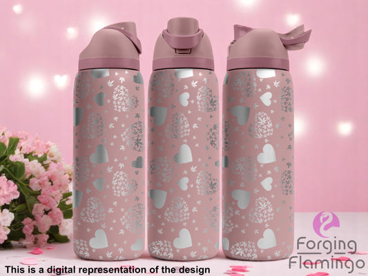 Three blush pink tumblers with flip-top lids, engraved with an all-over pattern of hearts and heart-shaped floral clusters, displayed against a soft pink background with string lights and pink flowers. Text below reads “This is a digital representation of the design.”
