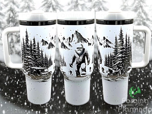 Composite image of a 40oz white tumbler with onyx engraving, featuring Forging Flamingo's Abominable Snowman design. Shown from multiple angles to highlight a snowy forest scene with Bigfoot, mountains, trees, and whimsical winter details in a seamless wrap. Part of our Bargain Bin collection.