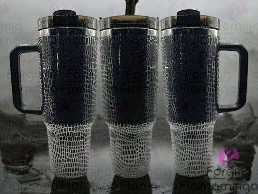 Composite image of a 40oz black tumbler with onyx engraving, featuring Forging Flamingo's Alligator/Crocodile Skin design. Shown from multiple angles to highlight bold, textured reptile scale patterns in a seamless, rugged wrap. Part of our Bargain Bin collection.