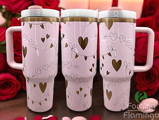 Composite image of a 40oz light pink tumbler with gold engraving, featuring Forging Flamingo's Boho Valentines design. Displayed from multiple angles to showcase hearts, arrows, rainbows, and boho elements in a seamless romantic wrap. Part of our Bargain Bin collection.