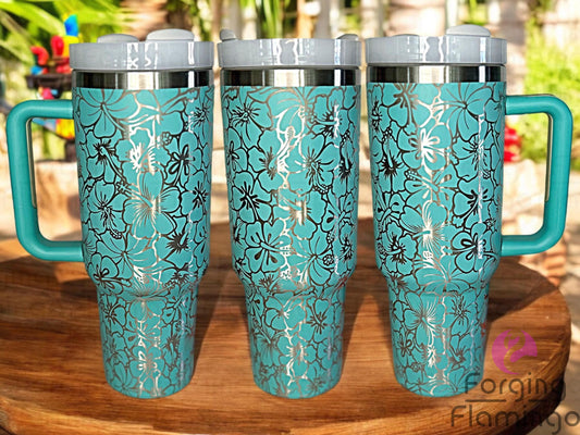Composite image of a teal Stanley tumbler engraved with Forging Flamingo's Hibiscus Flowers design on a stainless base, shown from multiple angles to highlight the tropical floral wrap with bold hibiscus blooms.
