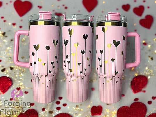 Composite image of a single tumbler engraved with Forging Flamingo's String of Hearts design, shown from multiple angles to display dangling heart shapes strung like garland in a continuous, romantic wrap.
